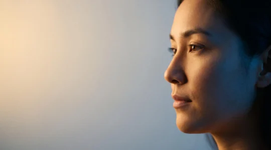 Portrait symbolique d'un visage humain partagé entre deux lumières opposées, illustrant la capacité à tenir deux pensées contraires en équilibre
